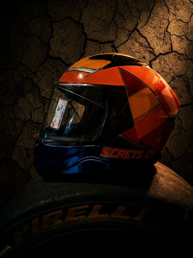 Casco de motociclista pintado en naranja y azul