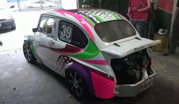 Fiat 600 de competición wrapeado en rosa, verde y violeta, número 39