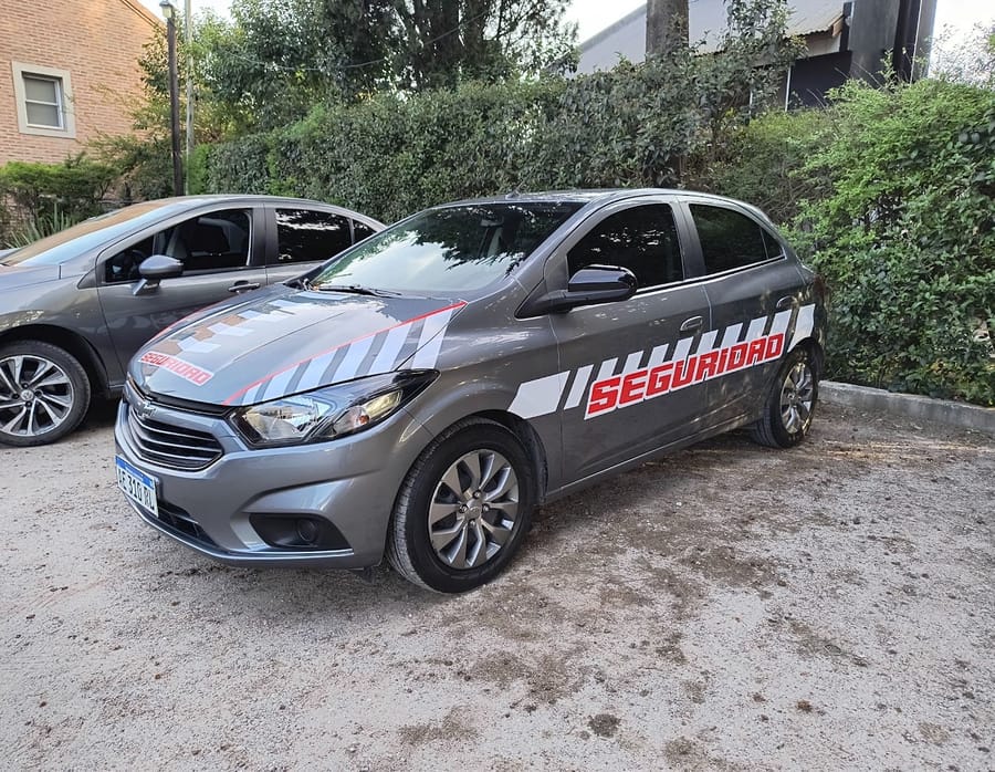Auto de empresa de seguridad wrapeado con franjas rojas y blancas